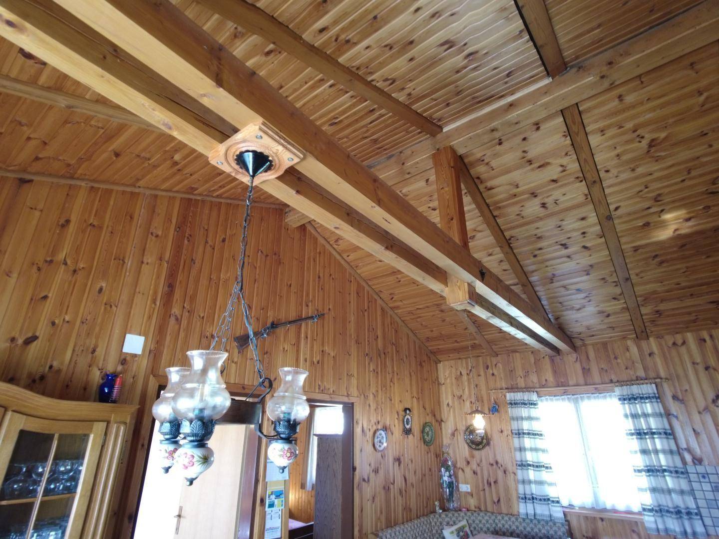Detailansicht der Holzdecke mit sichtbaren Balken und traditioneller Beleuchtung.