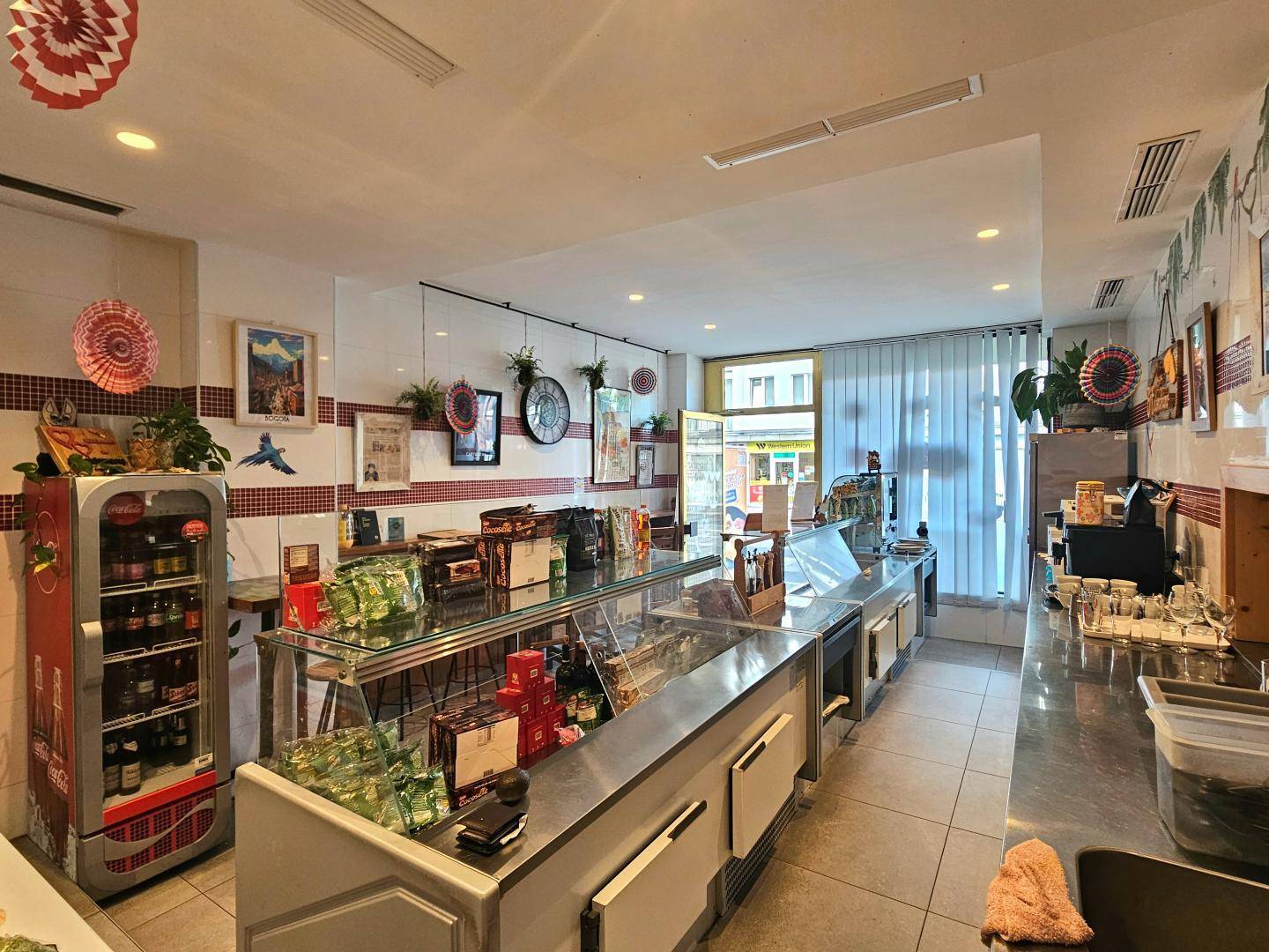 Verkaufsbereich mit langen Kühltheken, Arbeitsflächen und Fliesenboden.