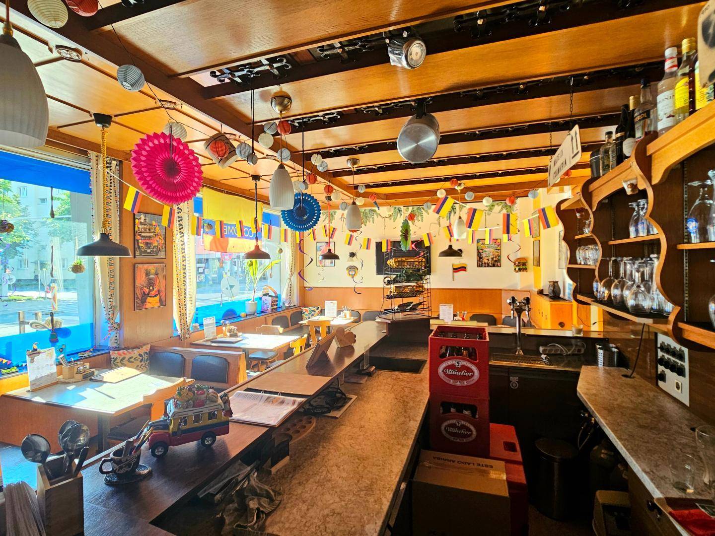 Geräumiger Gastraum mit Bar, Holztäfelung und vielen Sitzgelegenheiten für Gäste.
