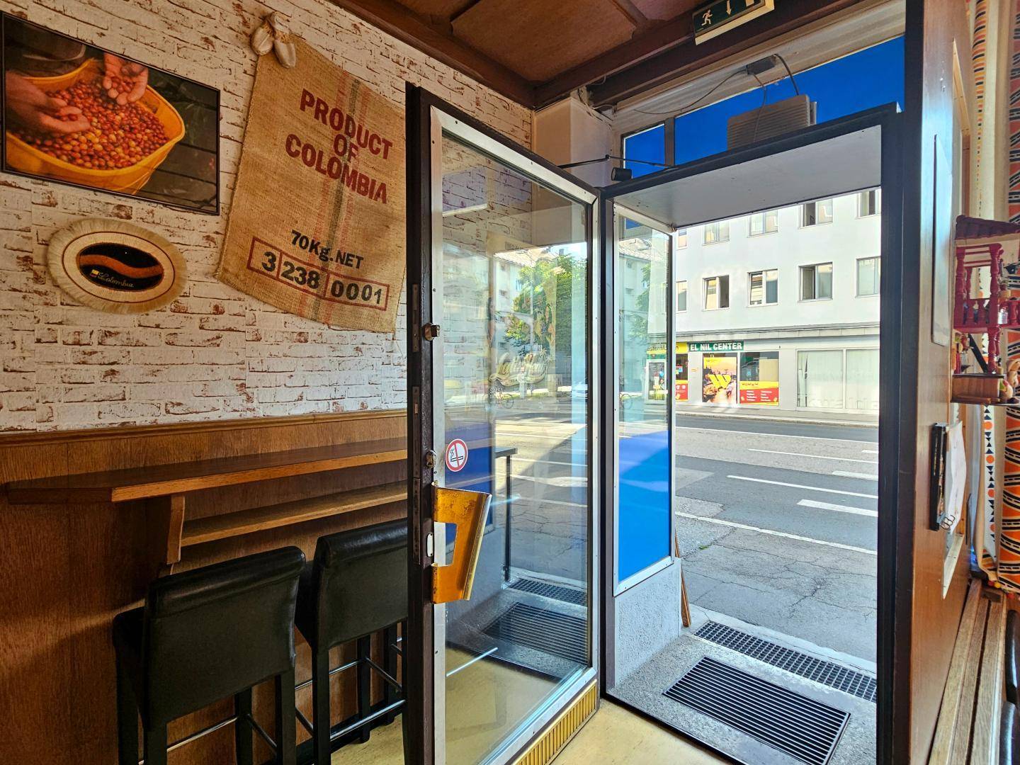 Heller Eingangsbereich des Restaurants mit Blick auf die Straße und einer kleinen Theke im Vordergrund.