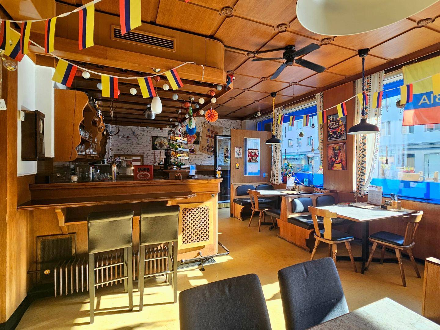 Einladender Gastraum mit Bar, Holzelementen und vielen Sitzgelegenheiten für eine angenehme Atmosphäre.