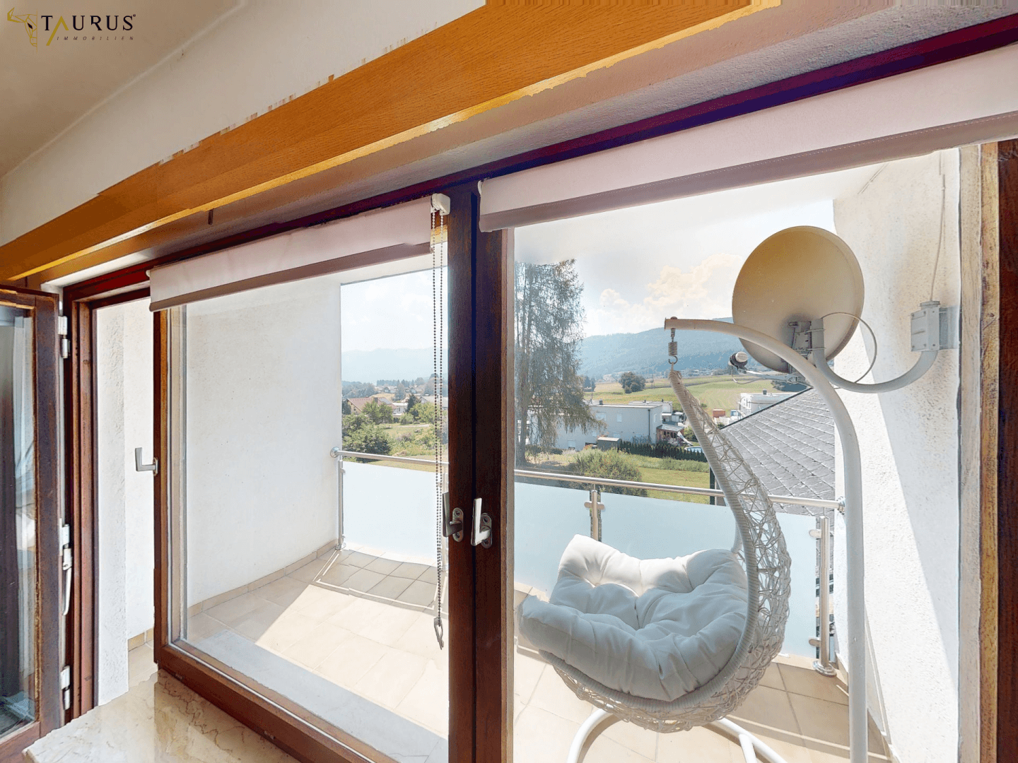 Balkon mit Hängesessel und weitem Blick über die Landschaft.