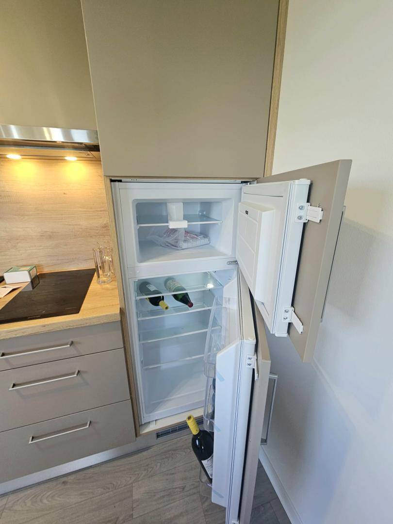 Integrierter Kühlschrank in der modernen Küchenzeile mit Stauraum für Lebensmittel.