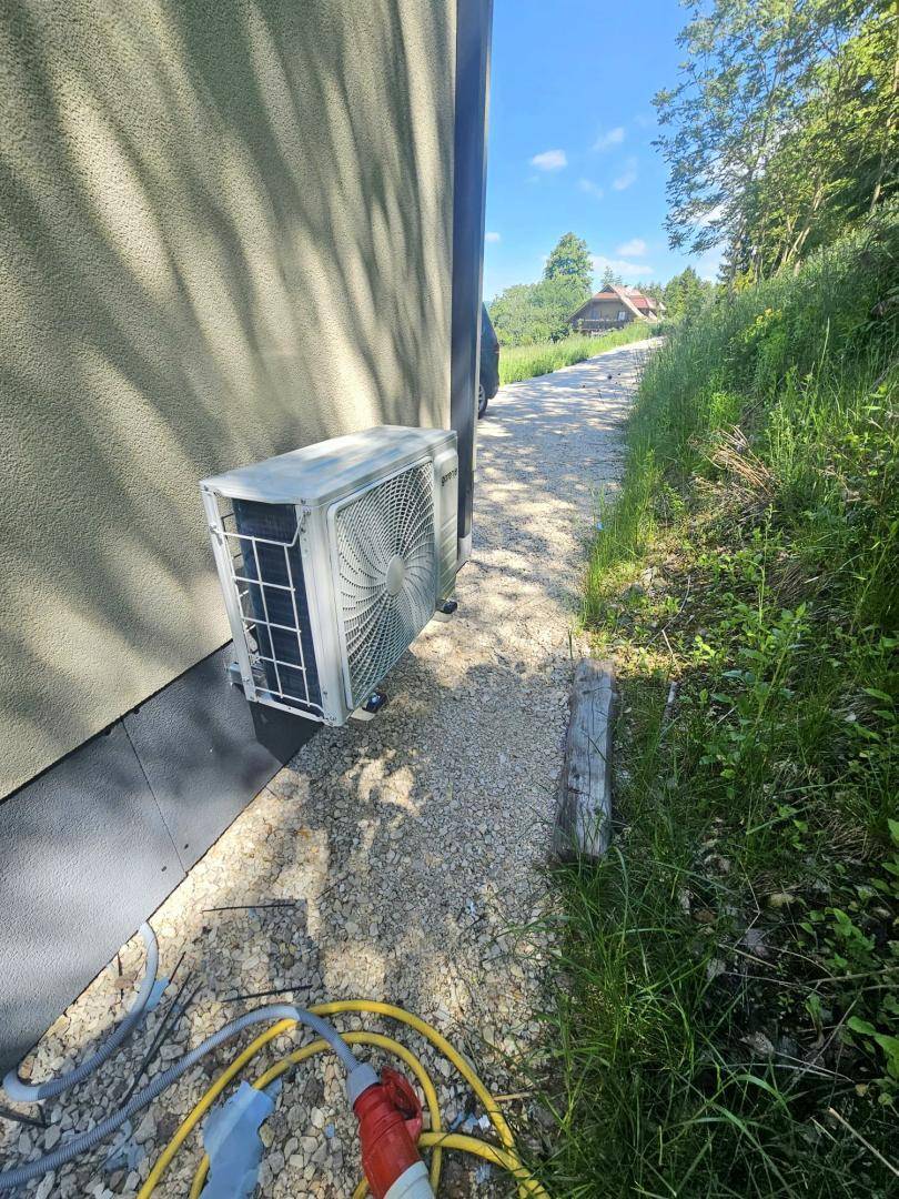 Außeneinheit einer Wärmepumpe oder Klimaanlage neben dem Gebäude.