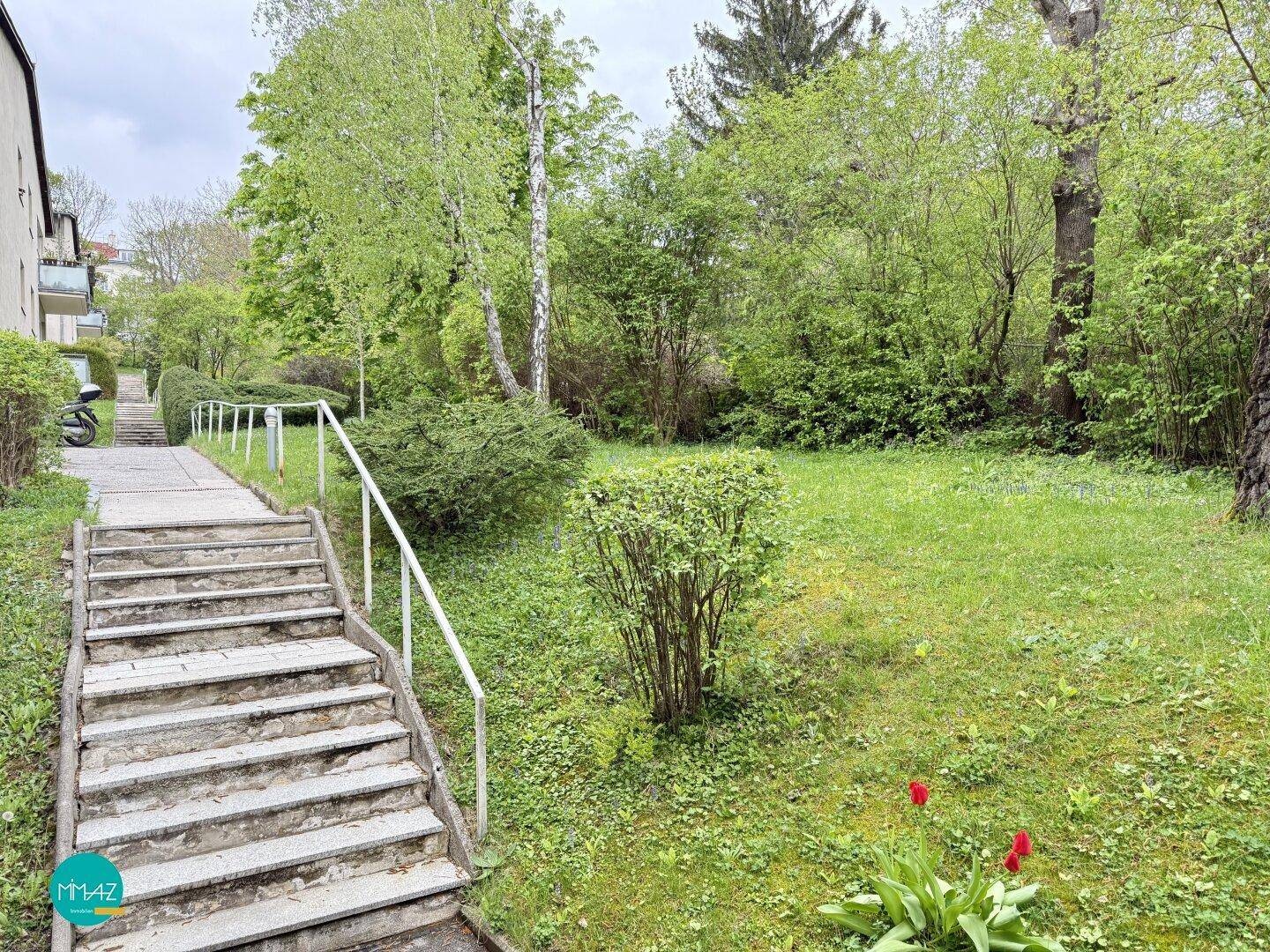 Gepflegter Gartenbereich mit Steintreppe und üppigem Grün, ideal zum Entspannen im Freien.