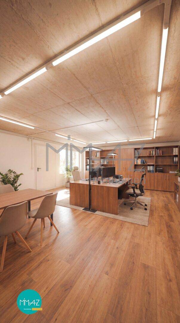 Modernes Büro mit Holzboden, großen Schreibtischen und Bücherregalen.