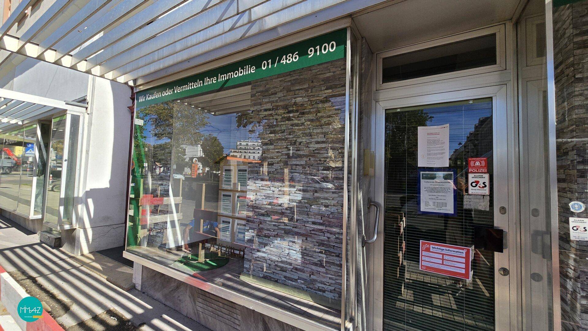 Außenansicht eines Geschäfts mit großer Schaufensterfront und Beschilderung, gut sichtbar von der Straße.