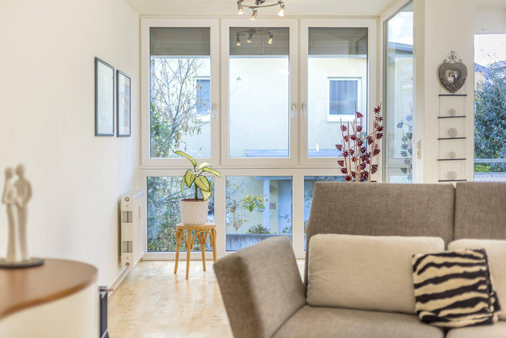 helles Wohnzimmer mit Wintergarten und Zugang zum Balkon