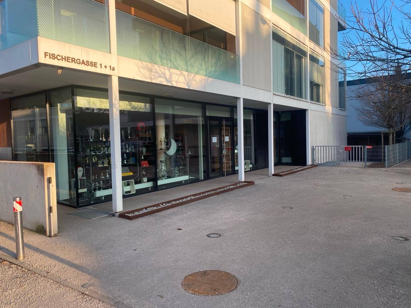 Eingangsbereich eines modernen Gebäudes mit Glasfronten und einer barrierefreien Rampe.
