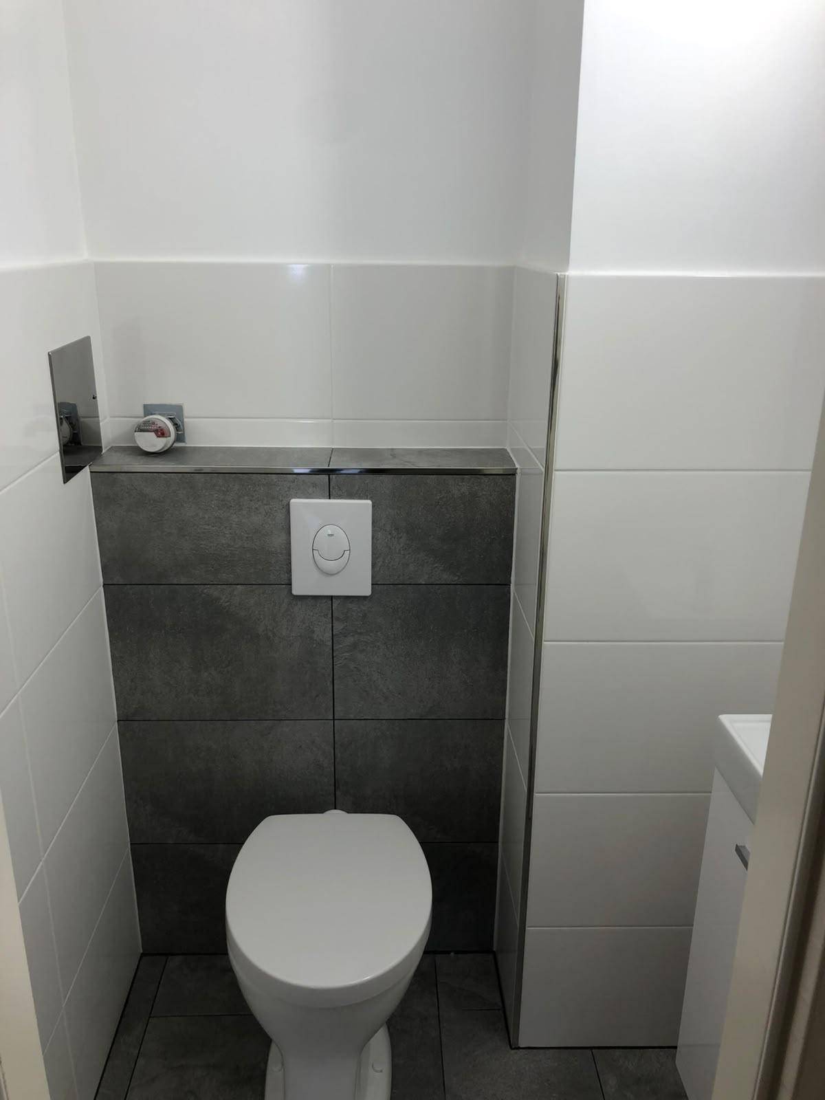 Modernes WC mit Wand-WC und stilvollen grauen und weißen Fliesen.