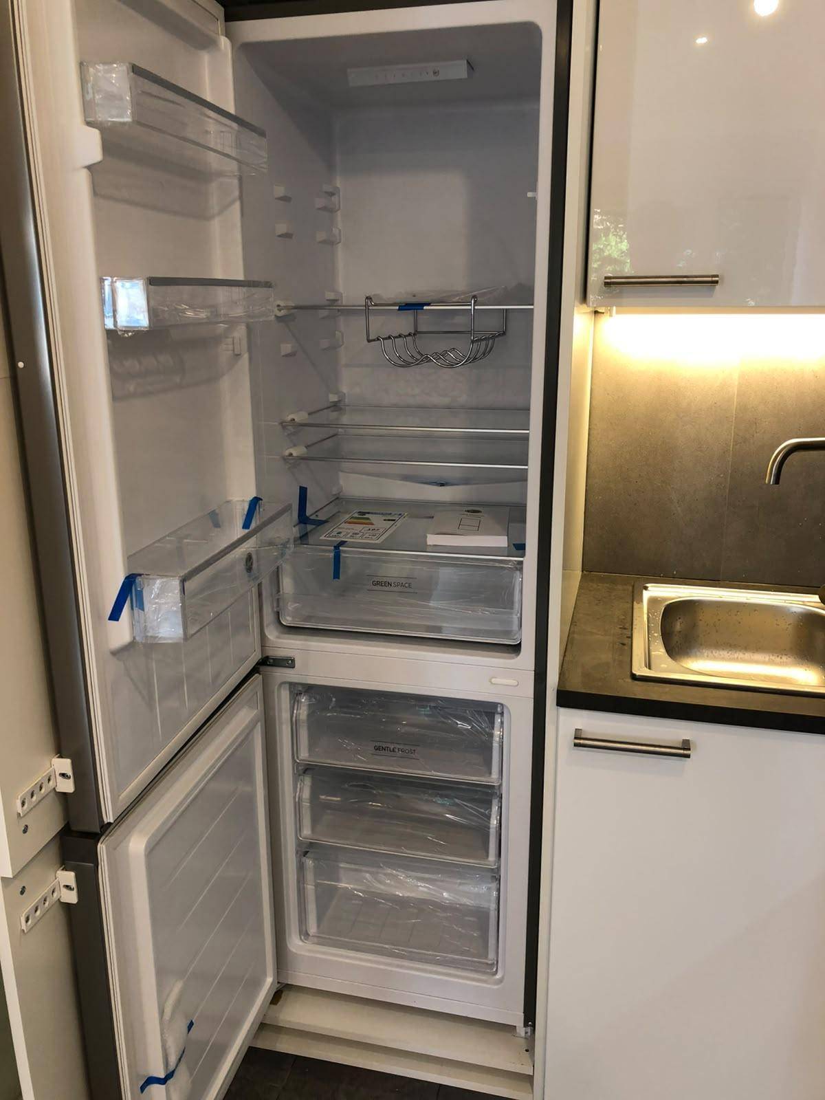 Offener Kühlschrank mit Gefrierfächern, nahtlos in die moderne Küchenzeile integriert.
