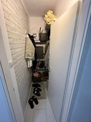 Praktischer Abstellraum mit Regalen für Kleidung und Schuhe.