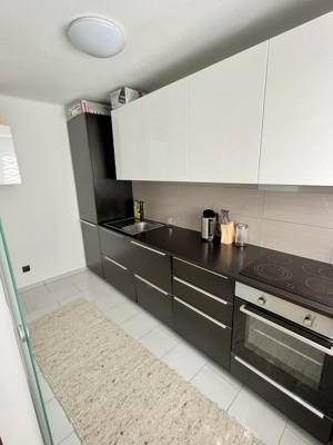 Funktionale Küche mit integriertem Backofen und Kochfeld, sowie viel Stauraum.