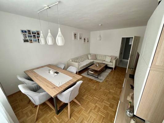 Geräumiger Wohn- und Essbereich mit Parkettboden und moderner Einrichtung.
