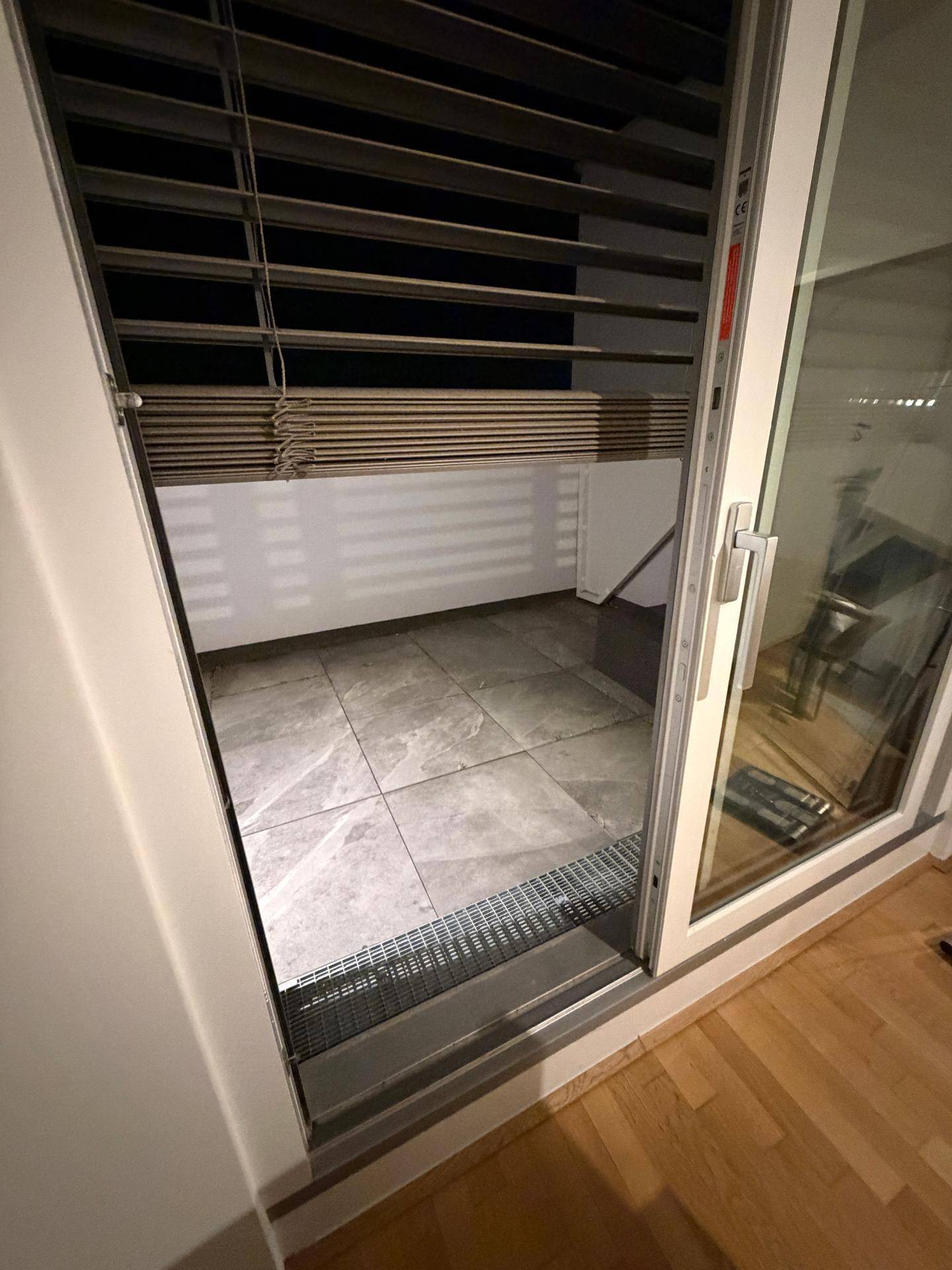 Geflieste Terrasse mit Jalousien, zugänglich vom Wohnbereich, bietet einen privaten Außenbereich.