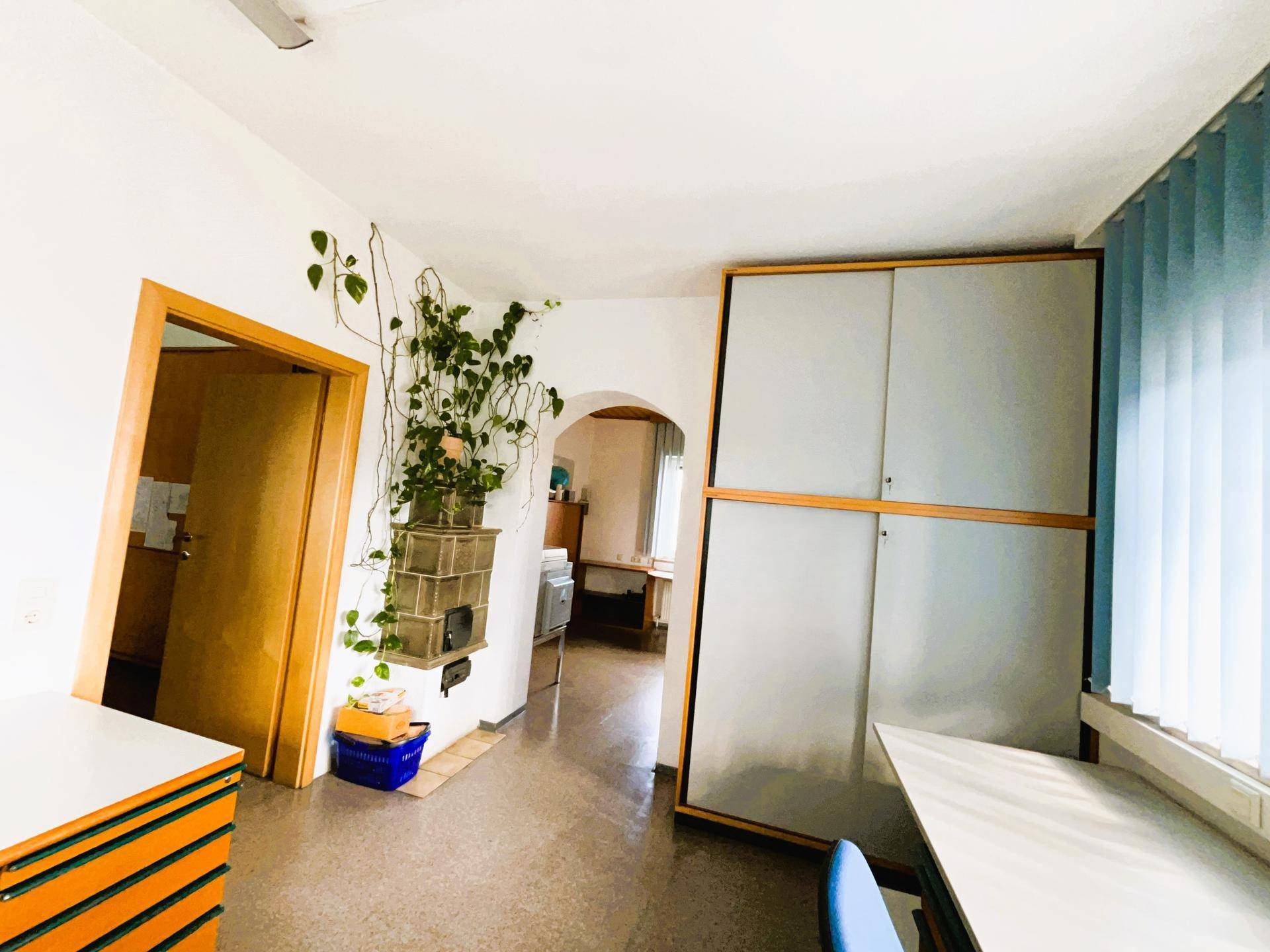 Büro mit einem traditionellen Kachelofen und einem großen Schrank, der Stauraum bietet.