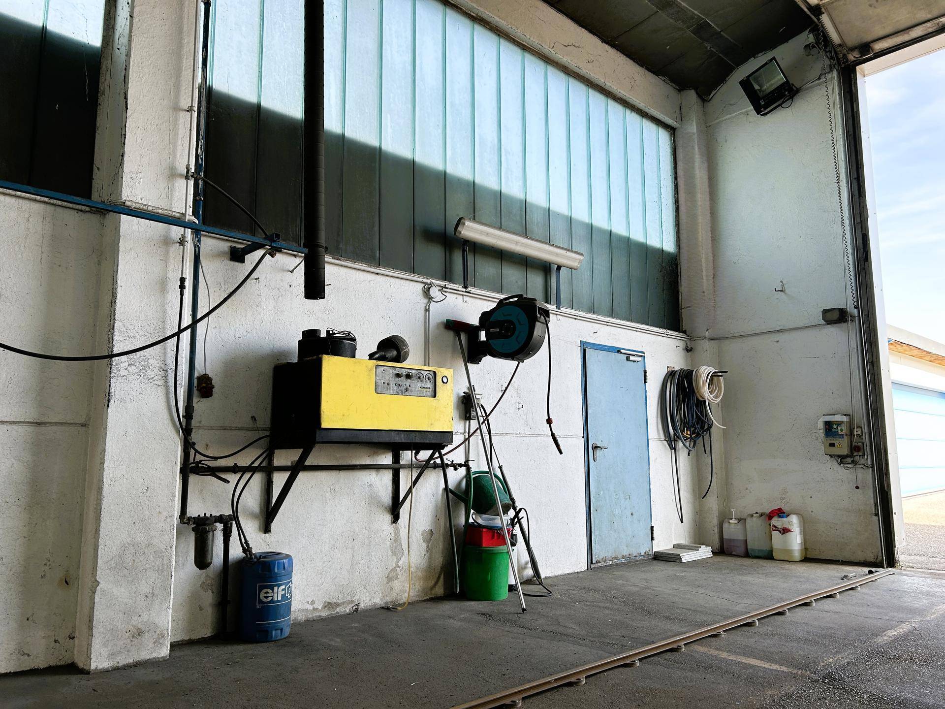 Bereich mit Kompressor und verschiedenen Anschlüssen, der die technische Infrastruktur der Werkstatt darstellt.