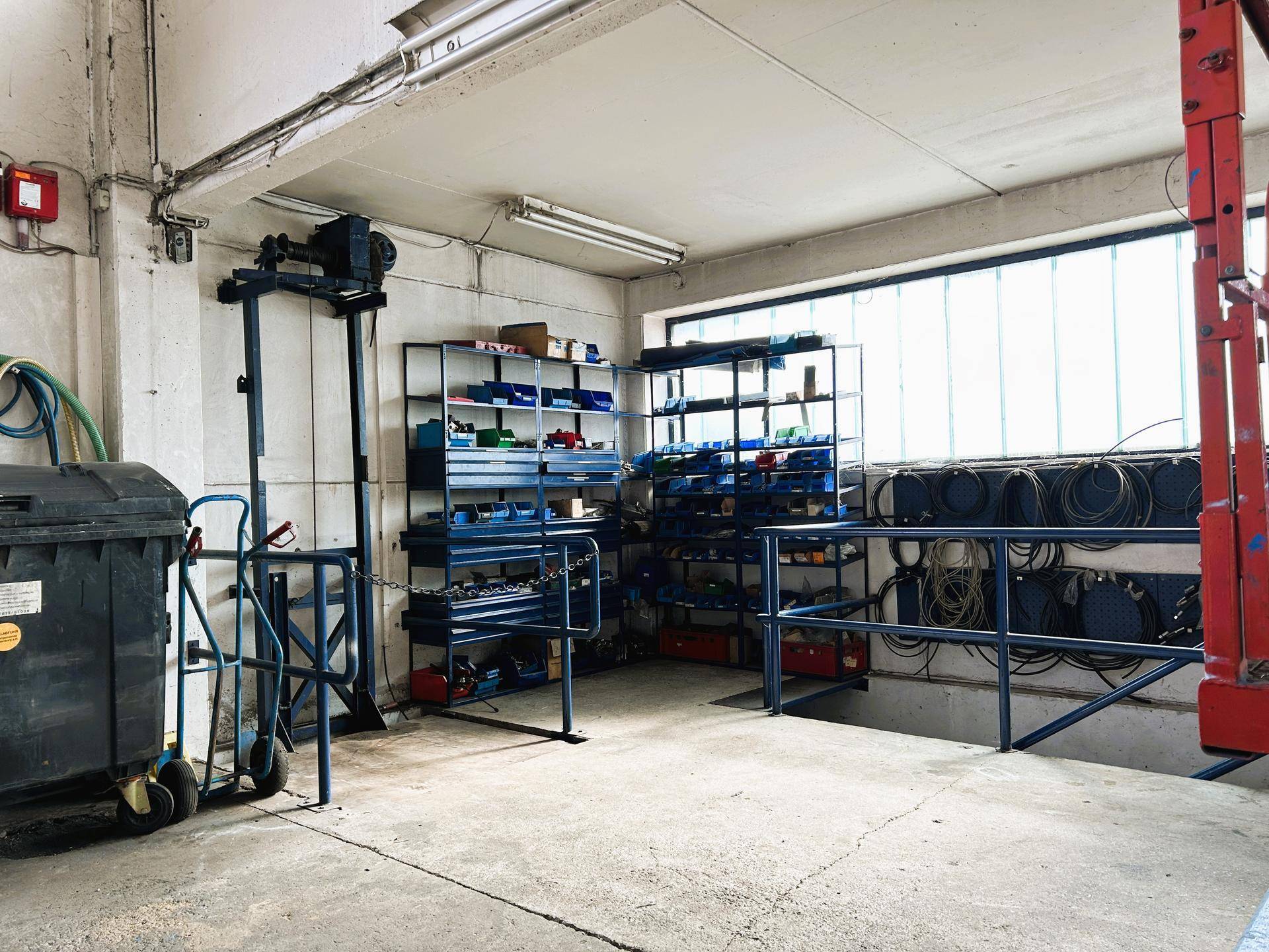 Lagerbereich mit Regalen voller Ersatzteile und Werkzeugen, gut beleuchtet und organisiert für den Werkstattbetrieb.
