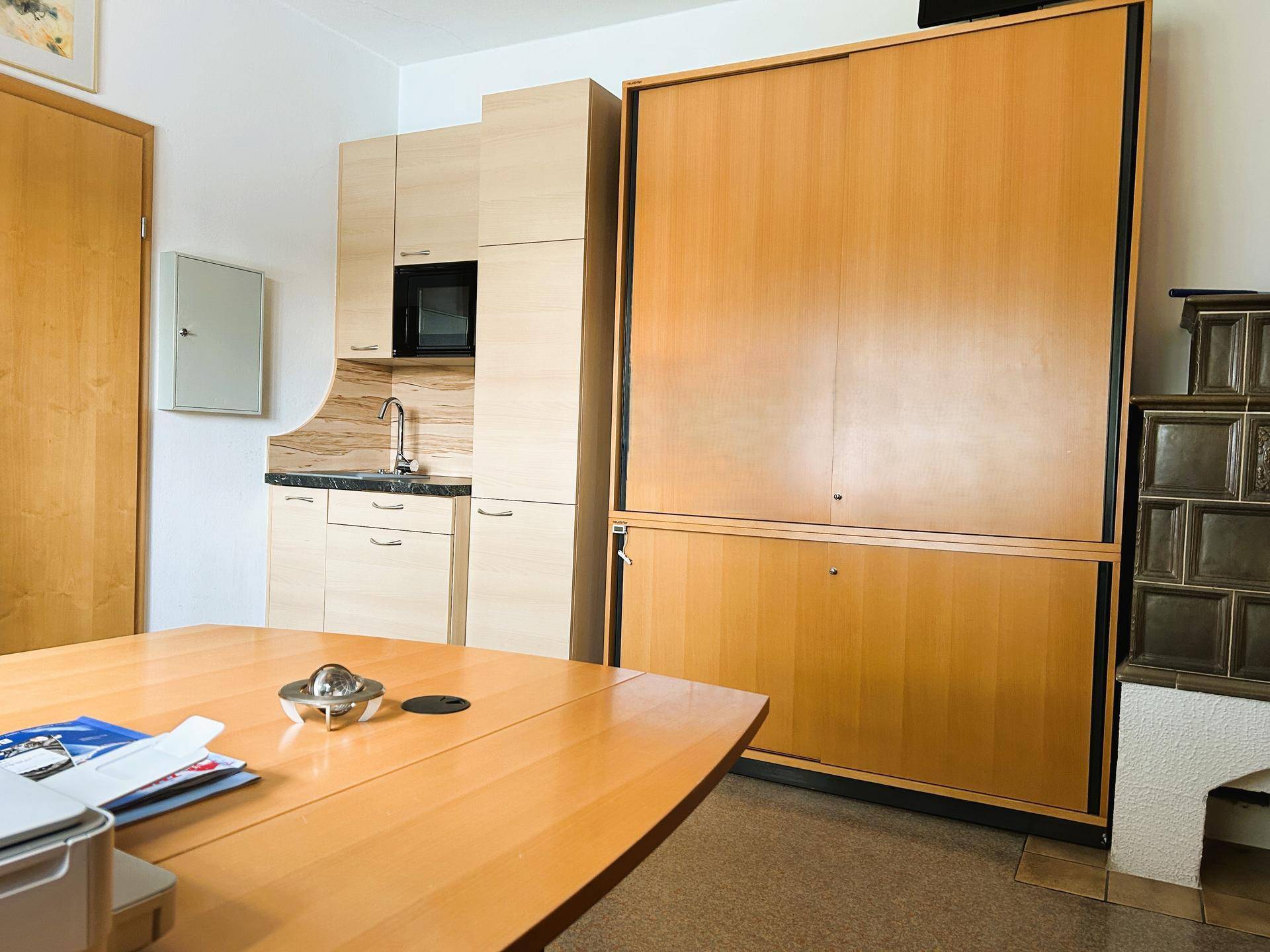 Büro mit integrierter Küchenzeile und einem großen Schrank, der zusätzlichen Stauraum bietet.