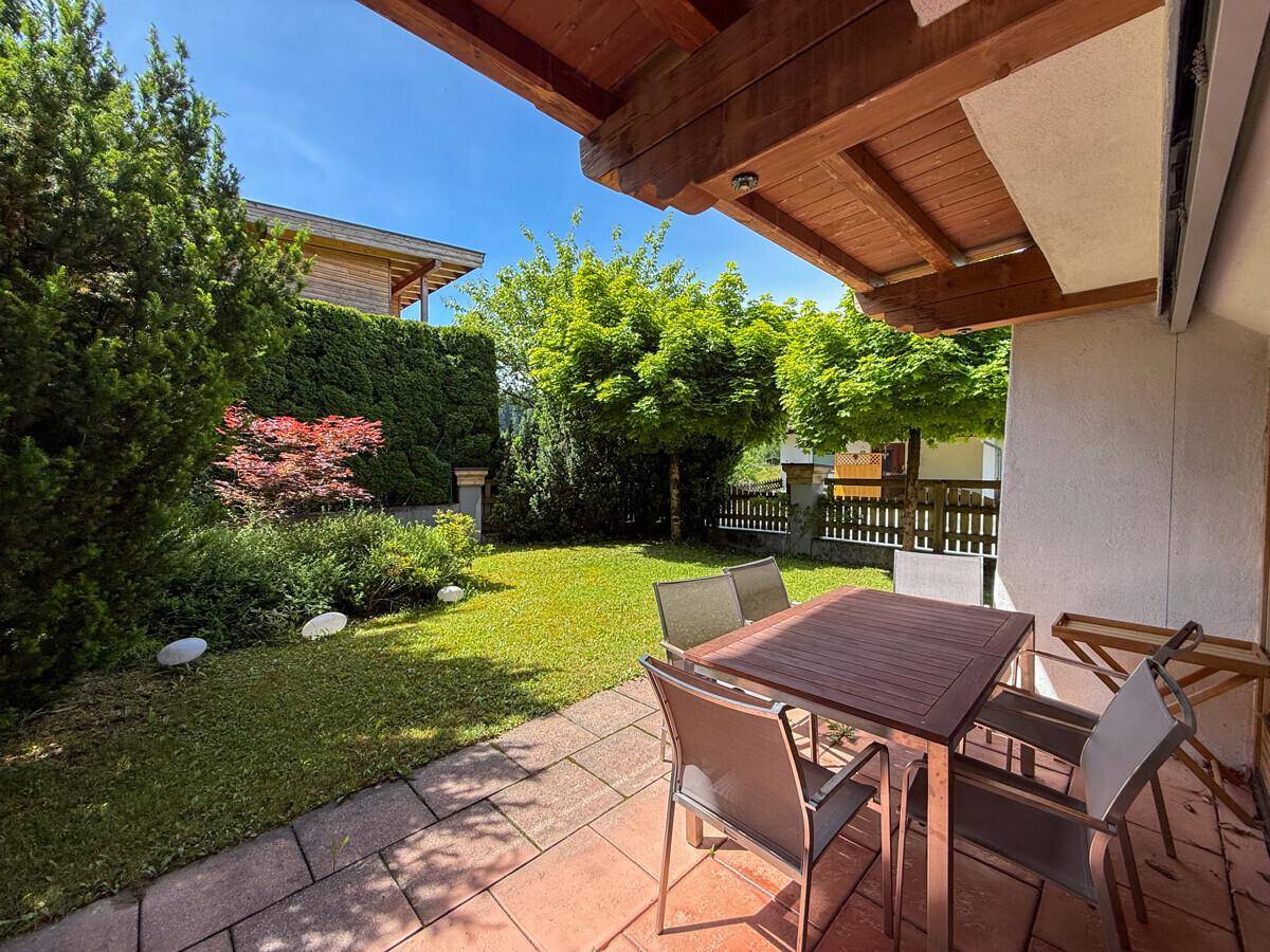Gemütliche Terrasse mit Gartenmöbeln und direktem Zugang zum gepflegten Rasenbereich.