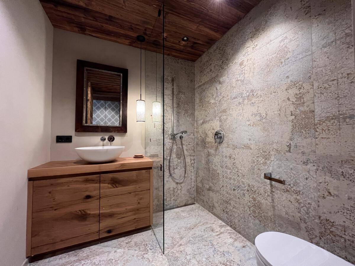 Stilvolles Badezimmer mit Holzwaschtisch, begehbarer Dusche und modernen Fliesen.