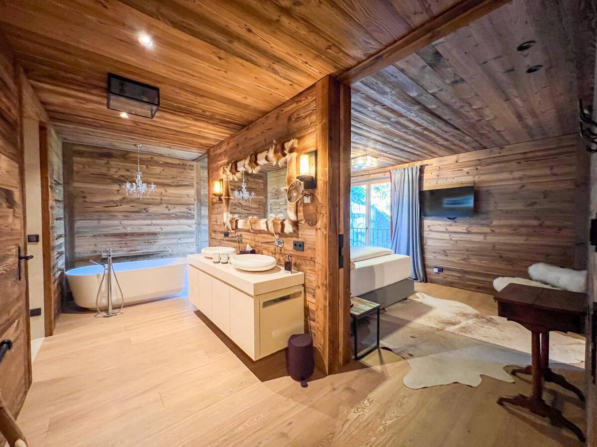Luxuriöses Badezimmer mit freistehender Badewanne, Doppelwaschbecken und offenem Zugang zum Schlafzimmer.