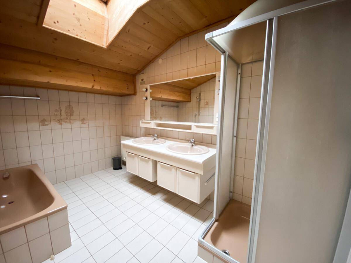 Badezimmer mit Doppelwaschbecken, Badewanne, Dusche und Dachfenster.
