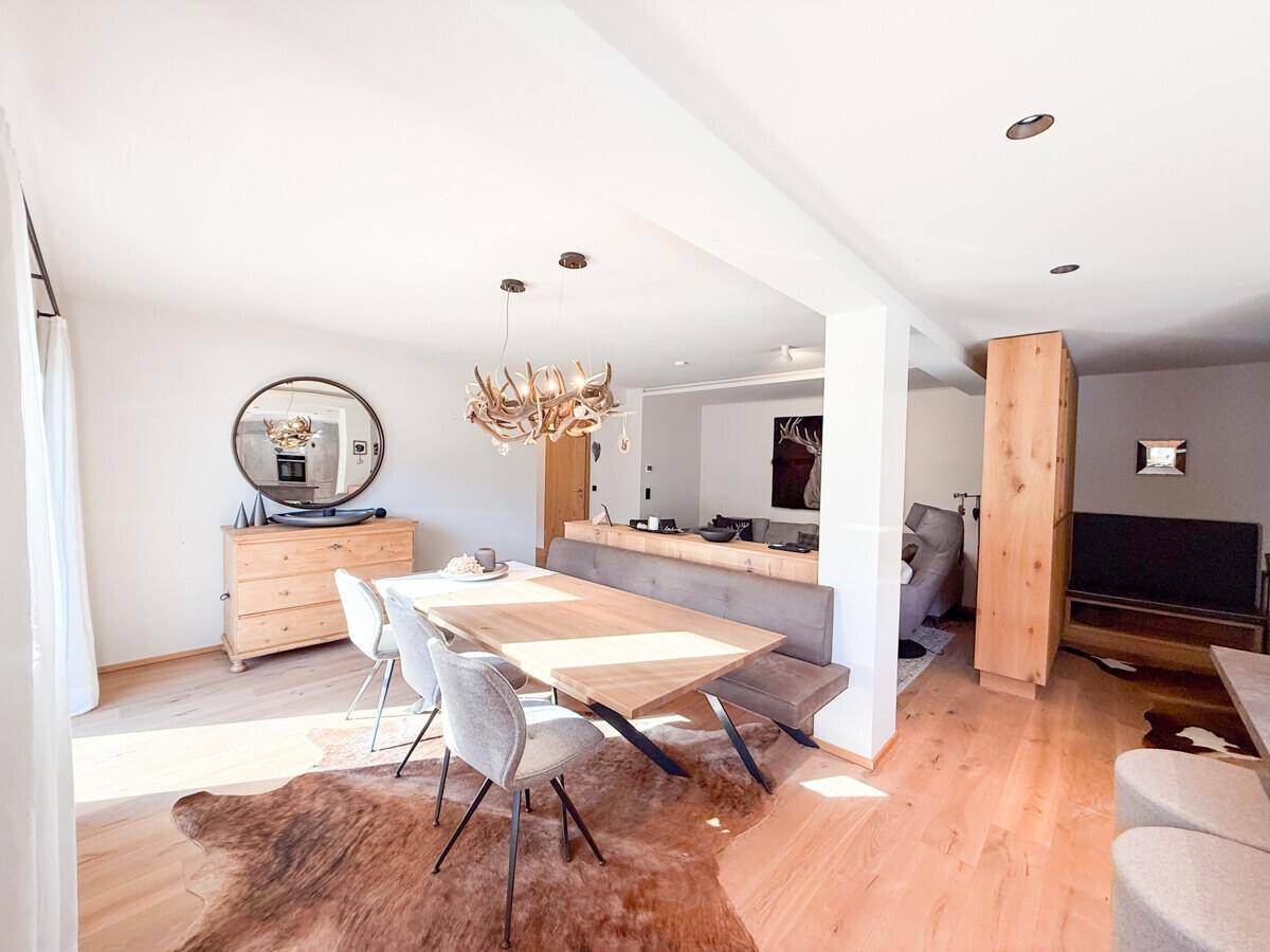 Gemütlicher Essbereich mit Holztisch, Sitzbank und Blick in den angrenzenden Wohnbereich.