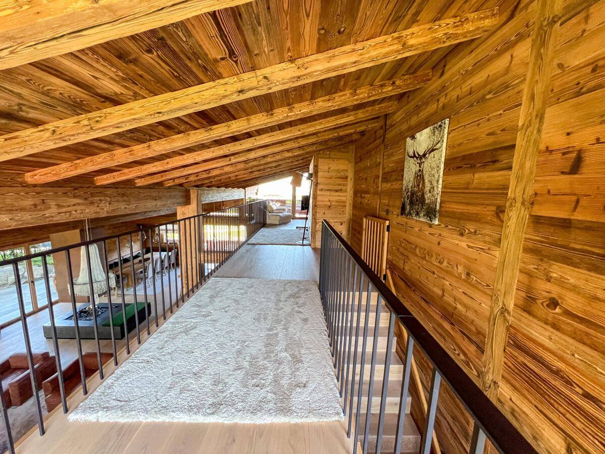 Helle Galerie mit Holzbalken und Blick auf den darunterliegenden Wohnbereich.