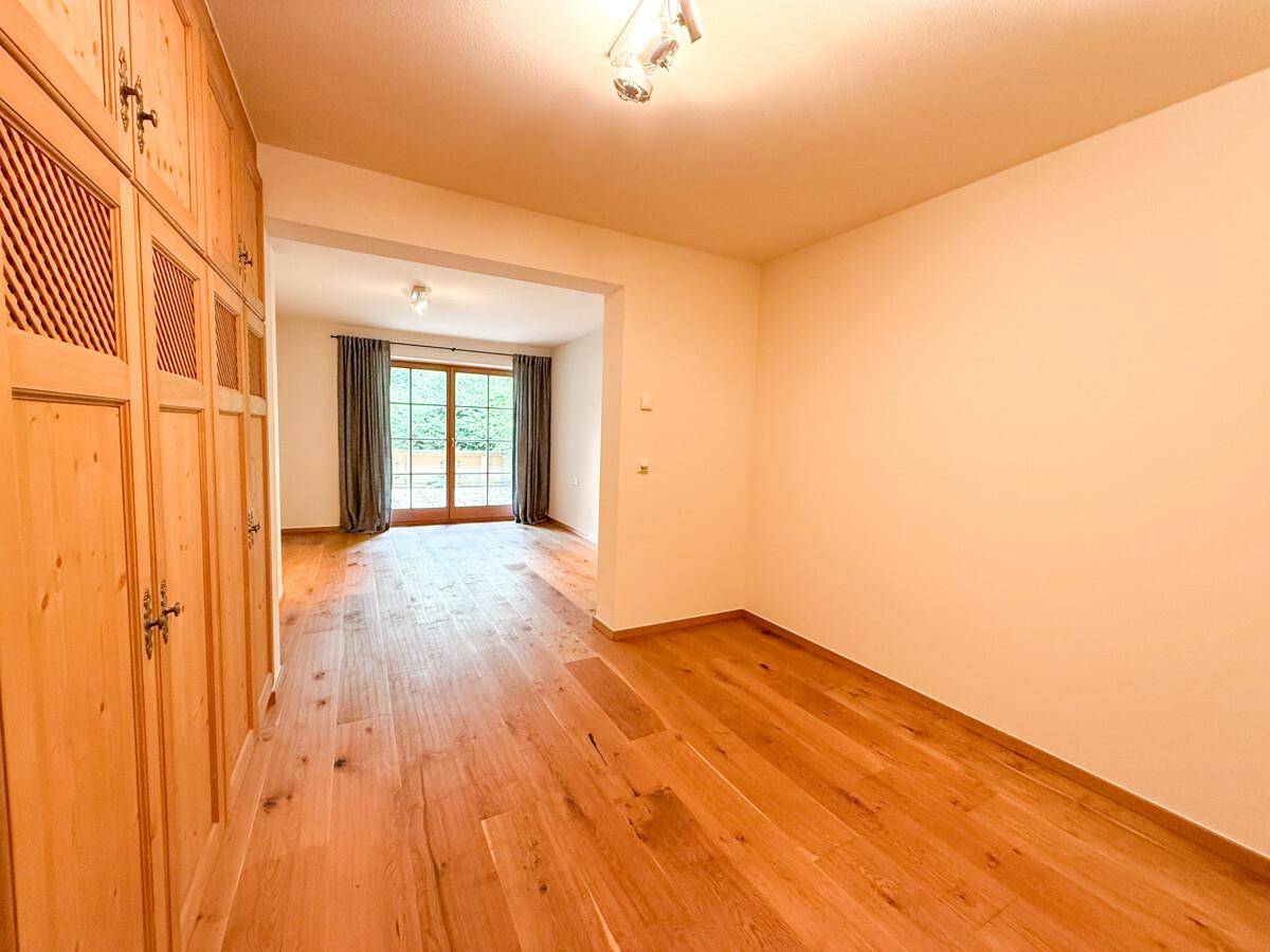 Flur mit Einbauschränken aus Holz und Blick auf den hellen Wohnbereich.