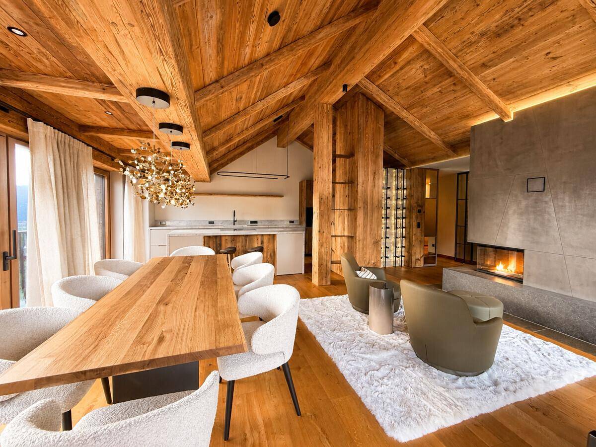 Offener Wohnbereich mit Holzbalkendecke, modernem Kamin und integriertem Weinkellerregal.