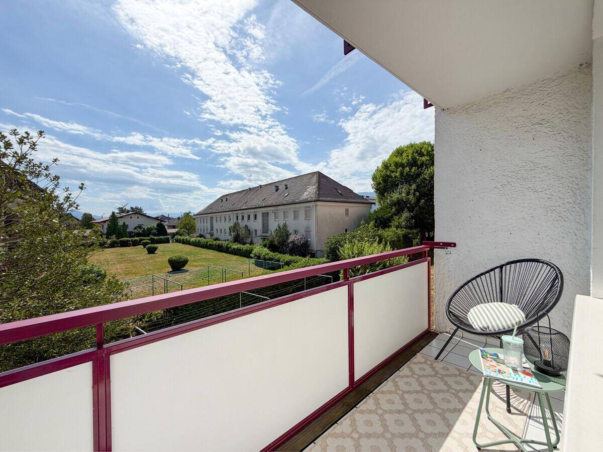 Sonniger Balkon mit Sitzgelegenheiten und weitem Blick auf die Umgebung.