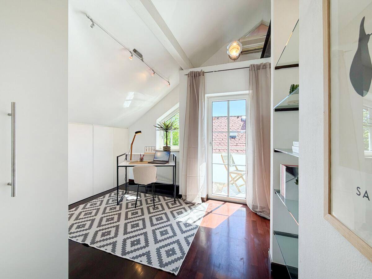 Helles Arbeitszimmer mit Schreibtisch und direktem Zugang zu einem Balkon, ideal für Home-Office.