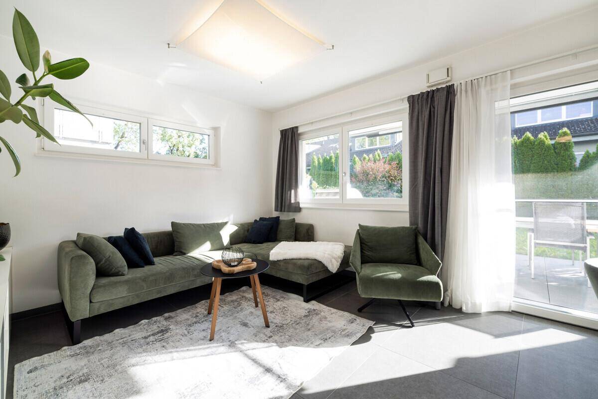 Helles Wohnzimmer mit bequemer Couch, modernen Möbeln und direktem Zugang zur Terrasse.