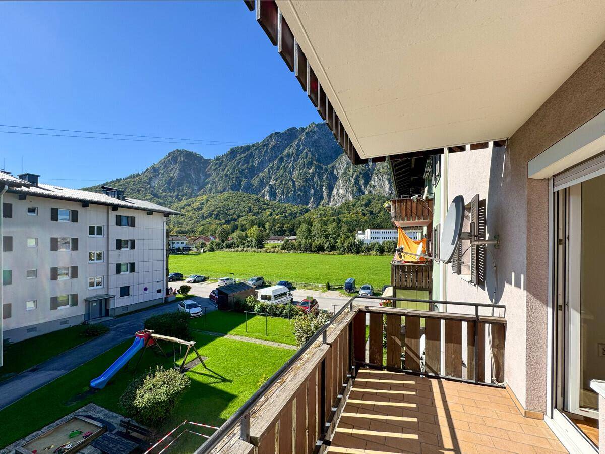 Balkon mit Bergblick, Kinderspielplatz und grüner Umgebung.