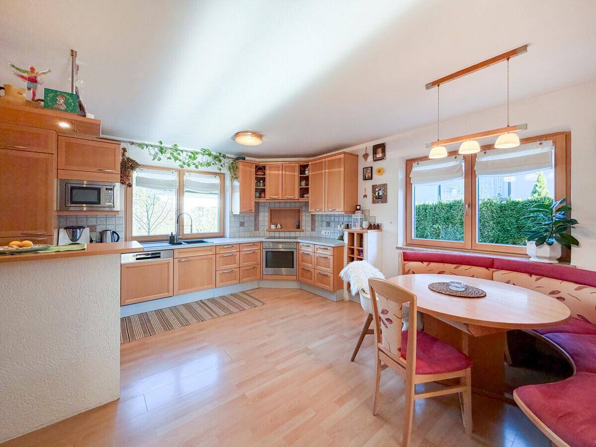 Schlafzimmer mit einer auffälligen orangefarbenen Akzentwand und hellem Holzboden.