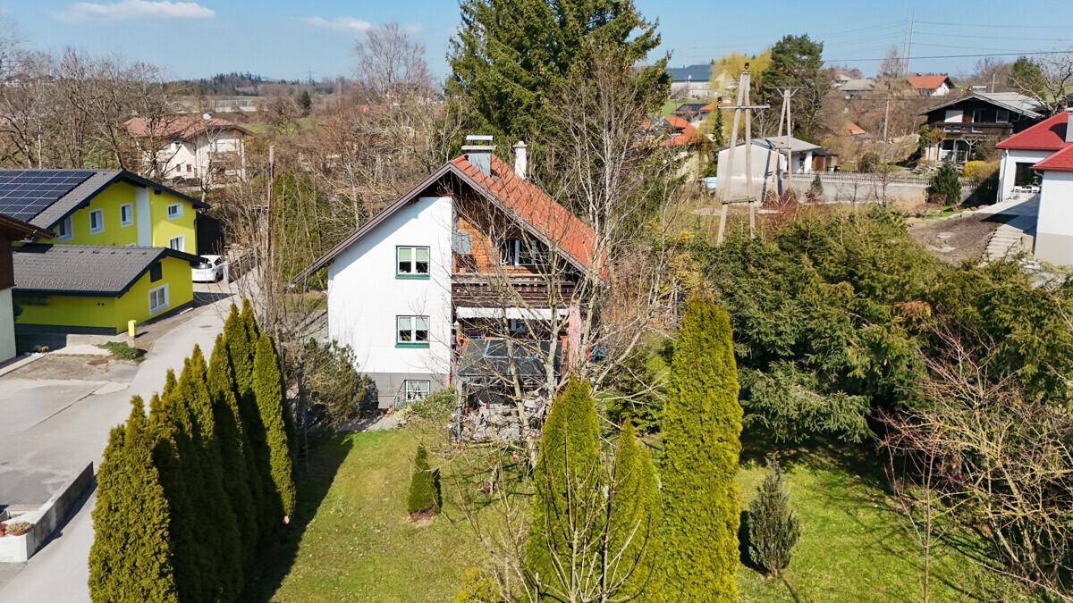 Luftaufnahme des Wohnhauses mit Garten und umliegender Wohnbebauung in sonniger Lage.