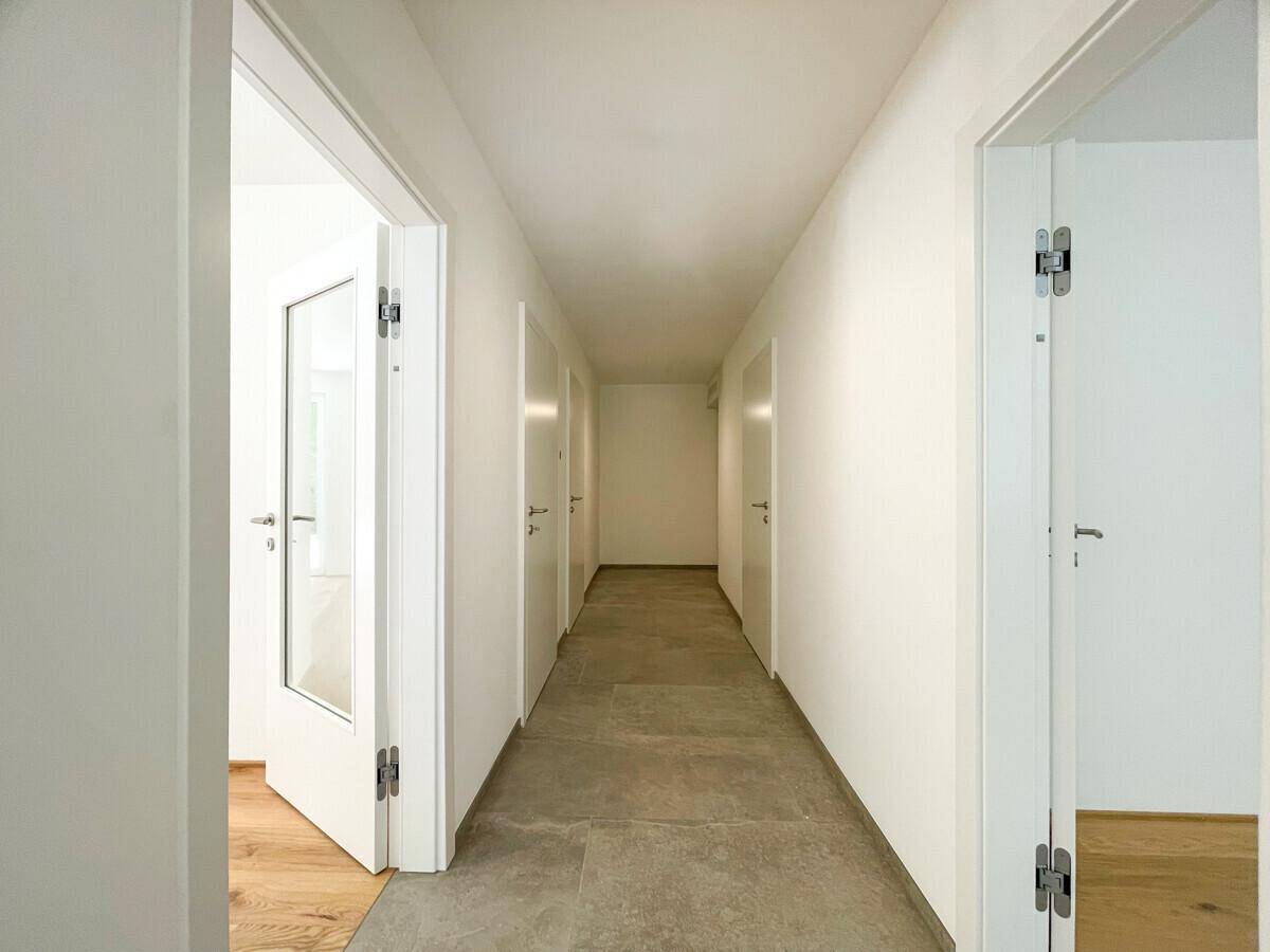 Heller Flur mit Fliesenboden und mehreren Türen zu den angrenzenden Räumen.