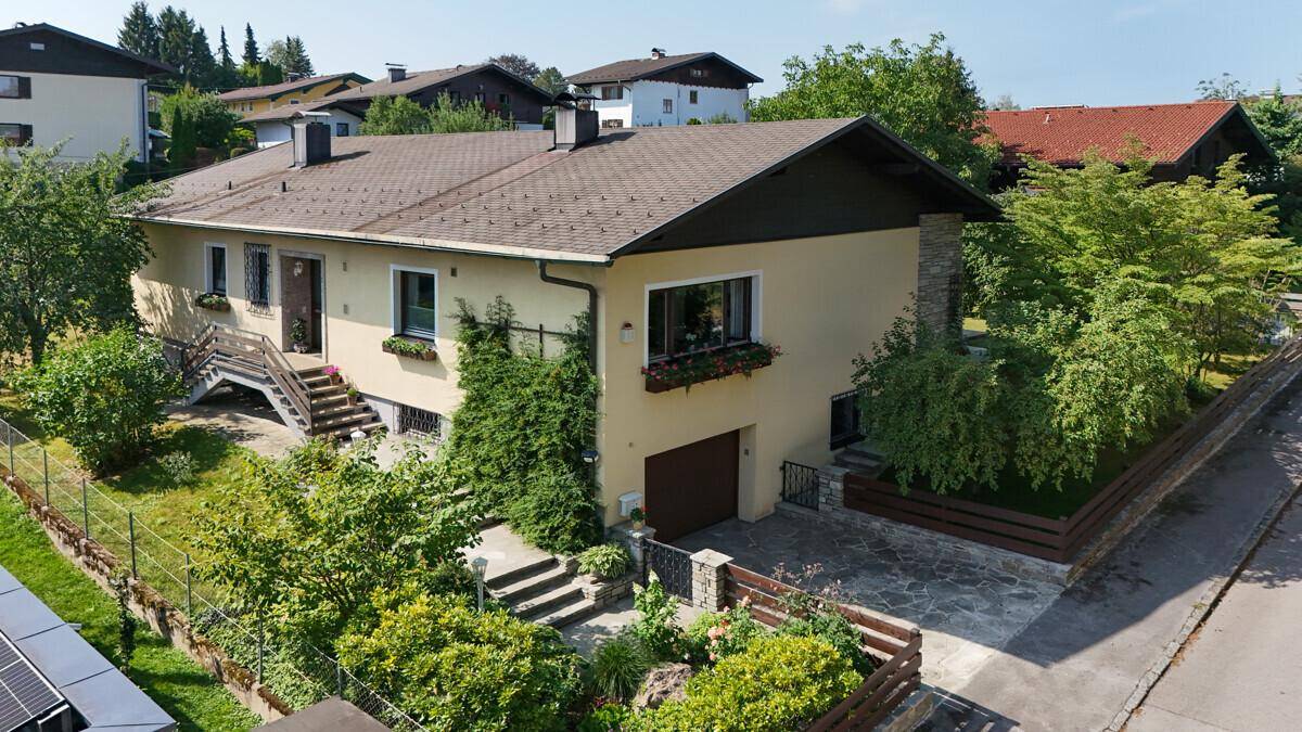 Vorderansicht des Hauses mit gepflegtem Vorgarten und Zufahrt zur Garage.