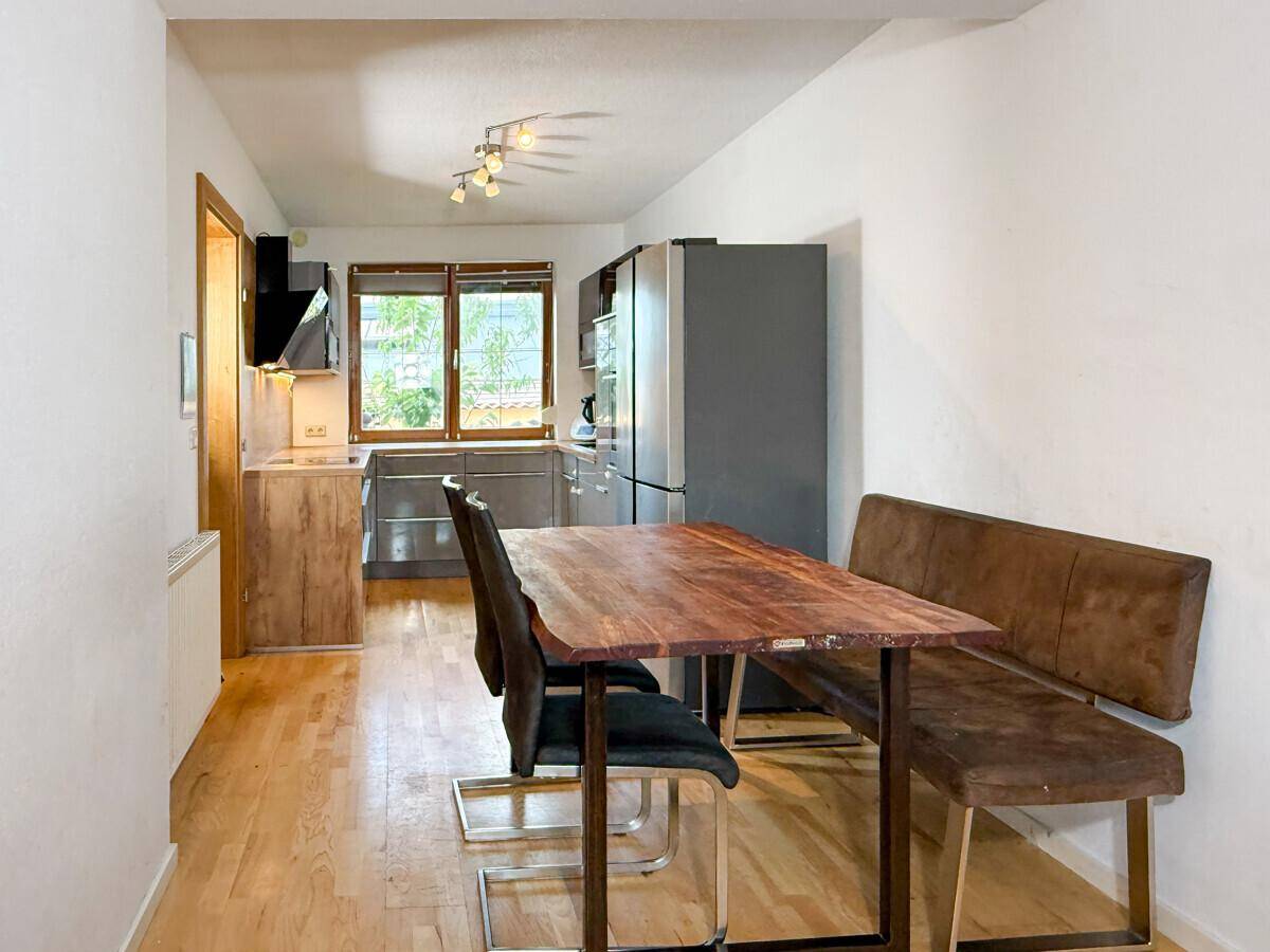 Wohnküche mit modernem Design, Holztisch und Sitzbank, ideal für Mahlzeiten.