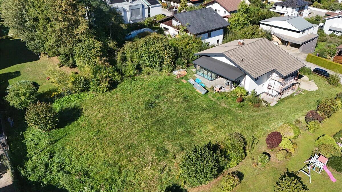 Weitläufiges Grundstück mit Einfamilienhaus und angrenzenden Gärten in ländlicher Umgebung, von oben betrachtet.