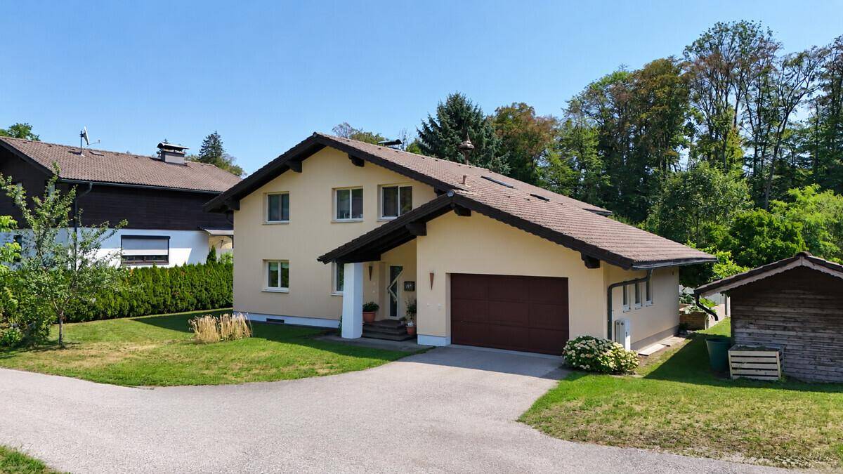 Einfamilienhaus mit integrierter Garage, Zufahrt und gepflegtem Vorgarten.