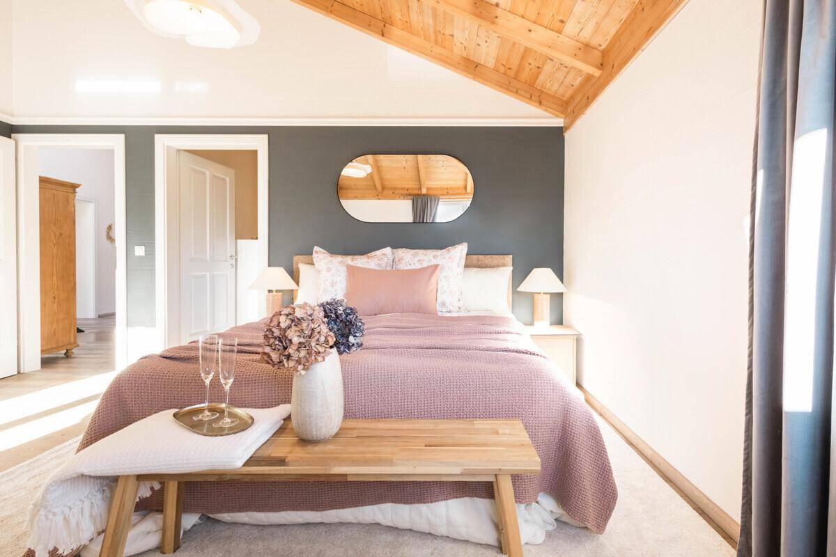 Helles Schlafzimmer mit Holzdachschräge, modernem Dekor und gemütlichem Ambiente.