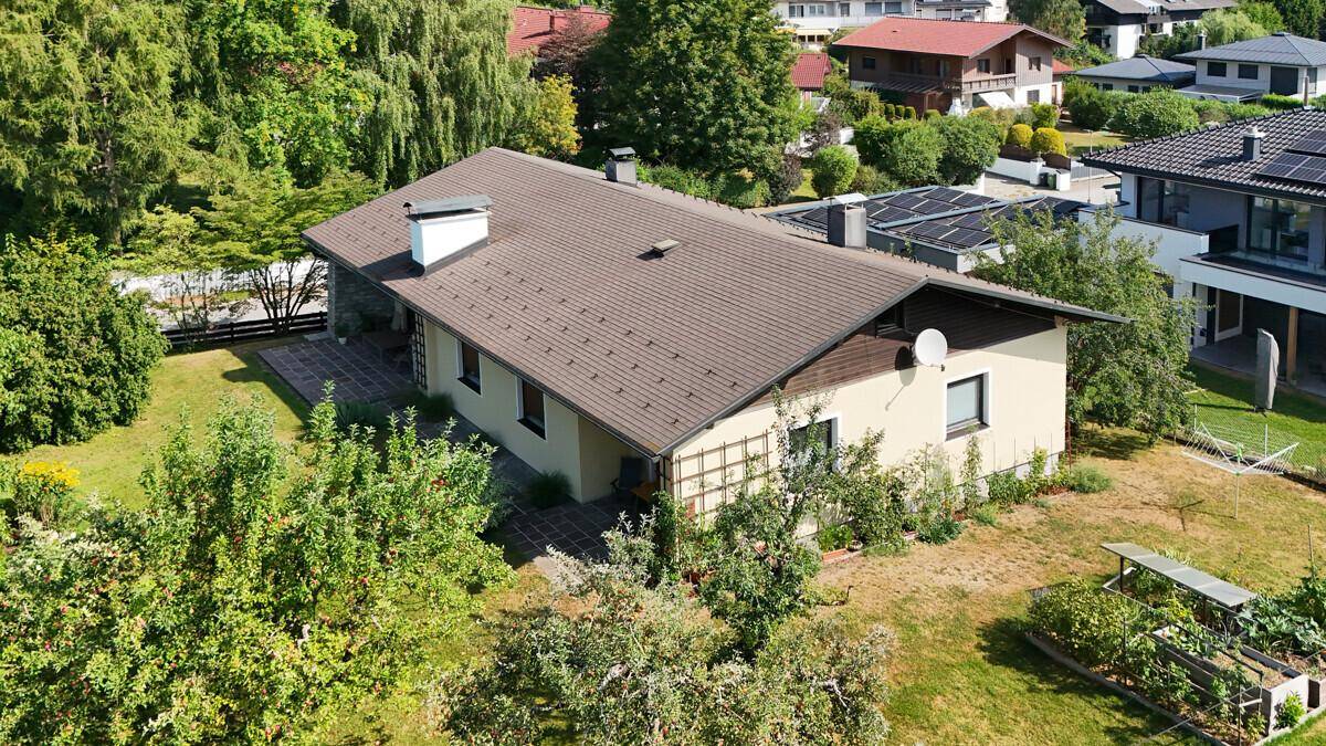 Weitläufiger Gartenbereich hinter dem Haus mit Obstbäumen und viel Grün.