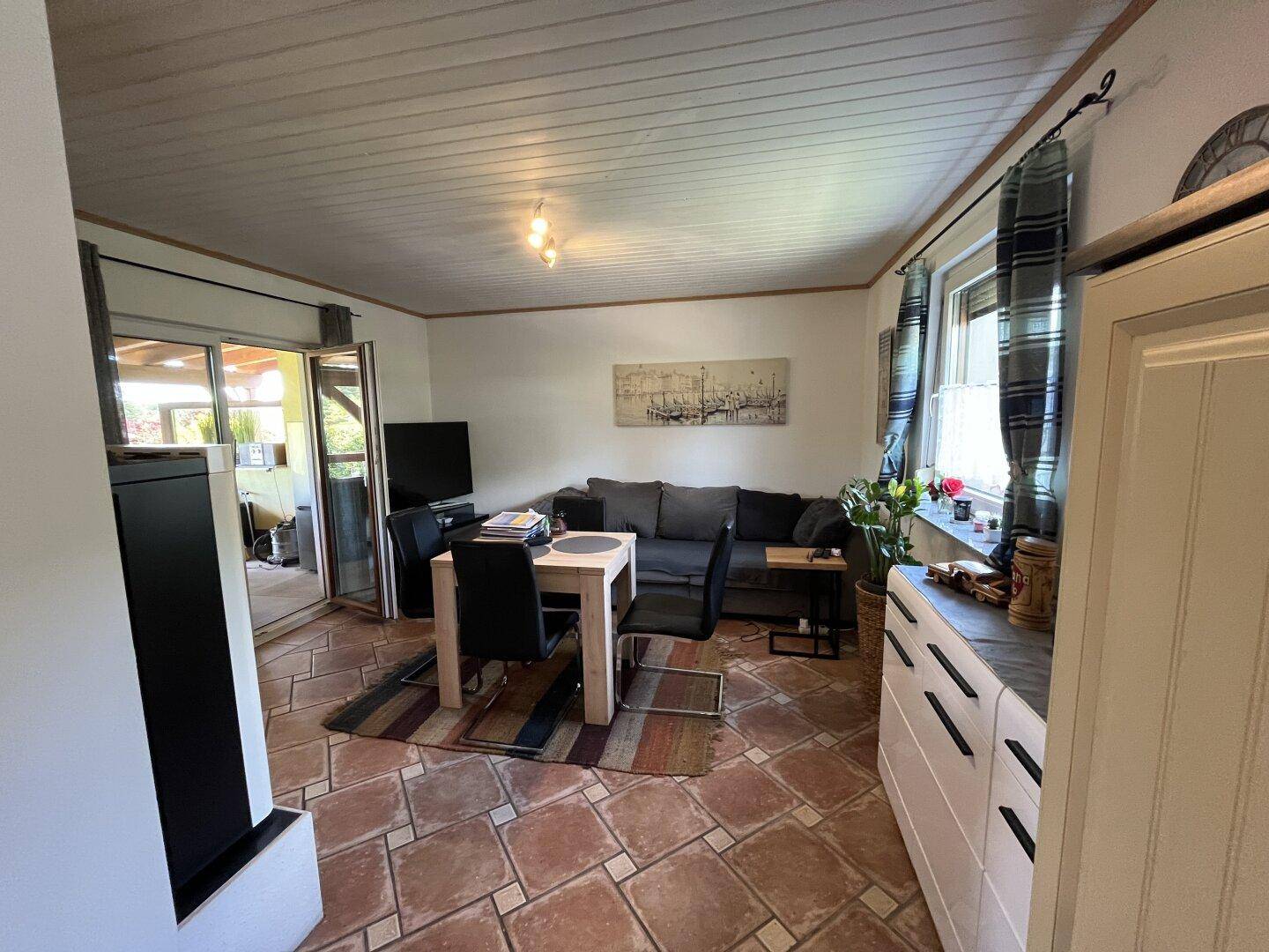 Offener Wohn-Essbereich mit Sofa, Esstisch und Zugang zur Terrasse, ideal für Familien.