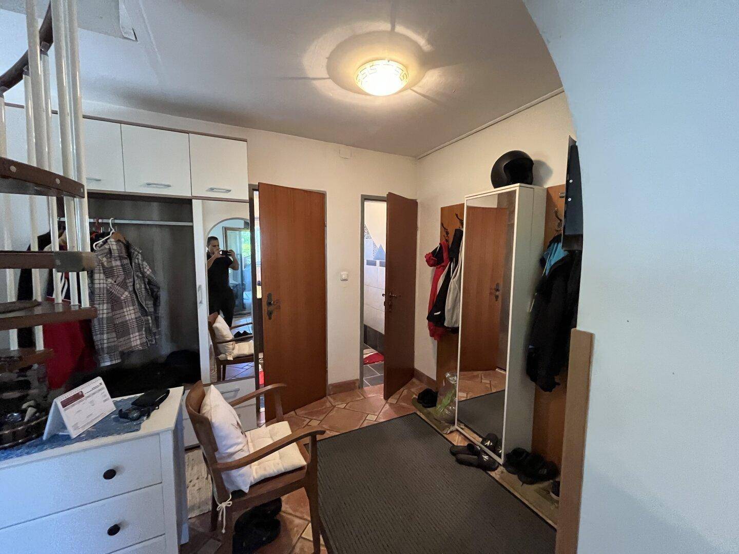 Geräumiger Flur mit Garderobe, Spiegel und Zugang zu verschiedenen Räumen.