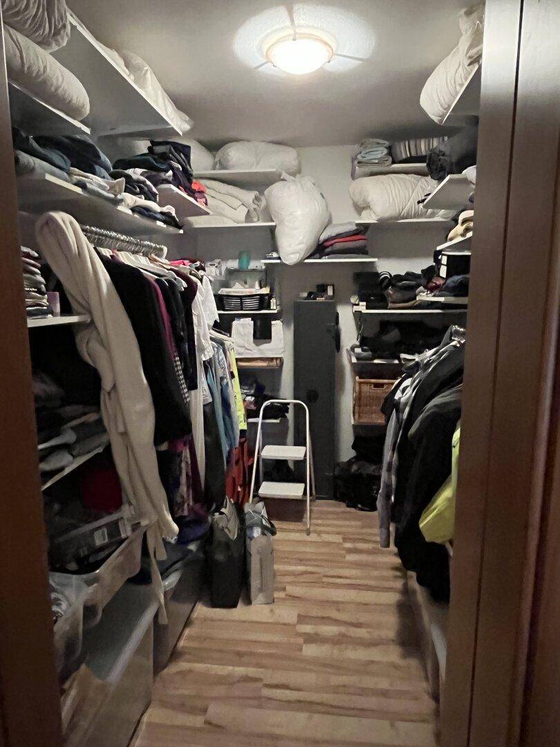 Praktischer begehbarer Kleiderschrank mit vielen Regalen und Stauraum für Kleidung.
