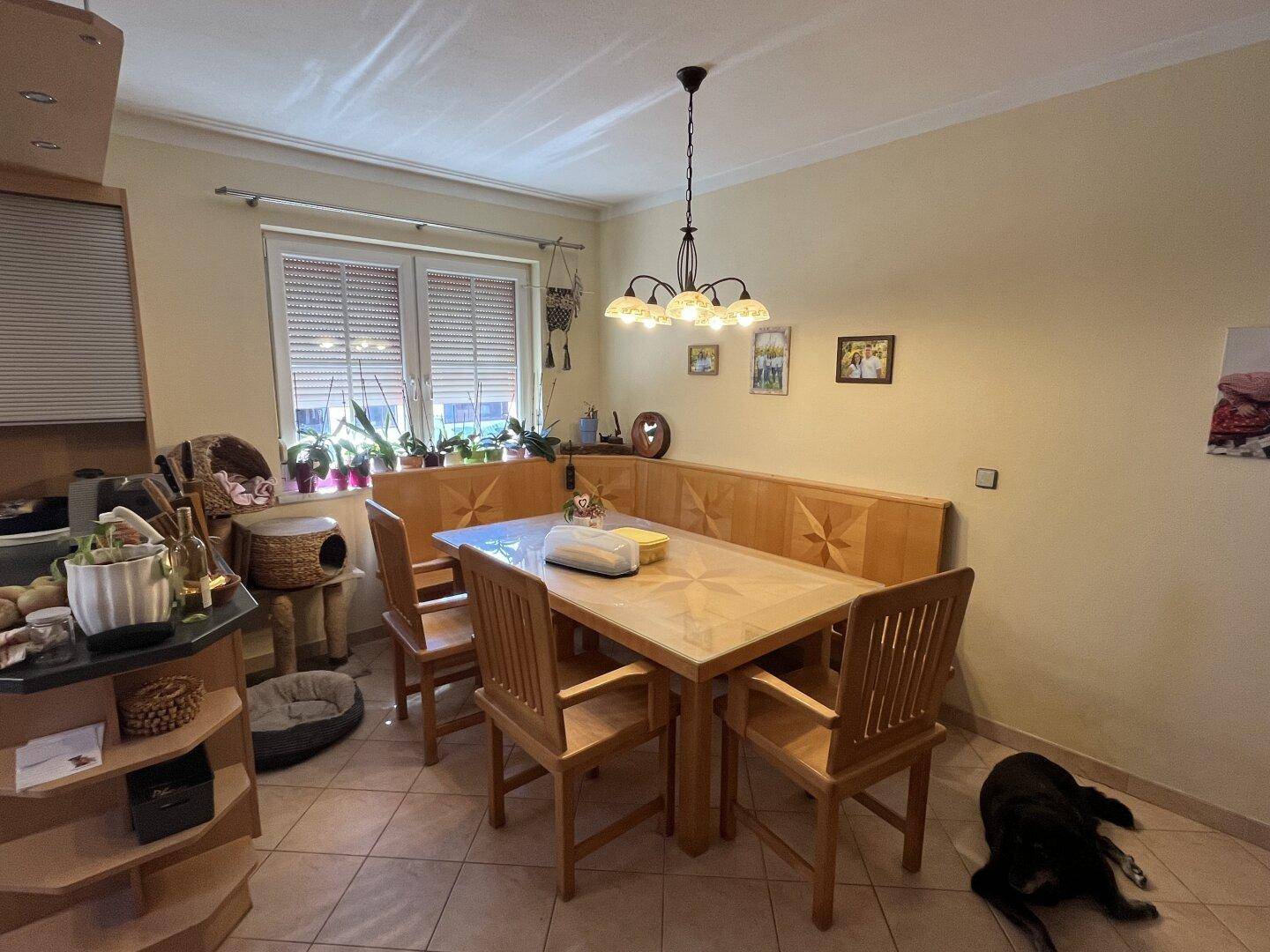 Heller Essbereich mit Holztisch, Eckbank und Fliesenboden, ideal für Familienmahlzeiten.
