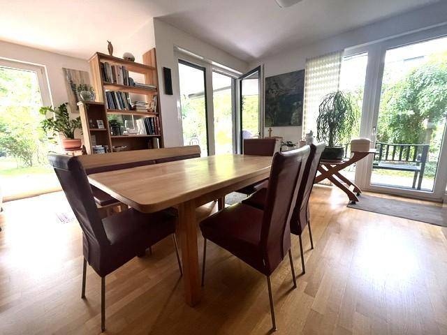 Heller Essbereich mit Holztisch, Stühlen und direktem Zugang zum grünen Garten.