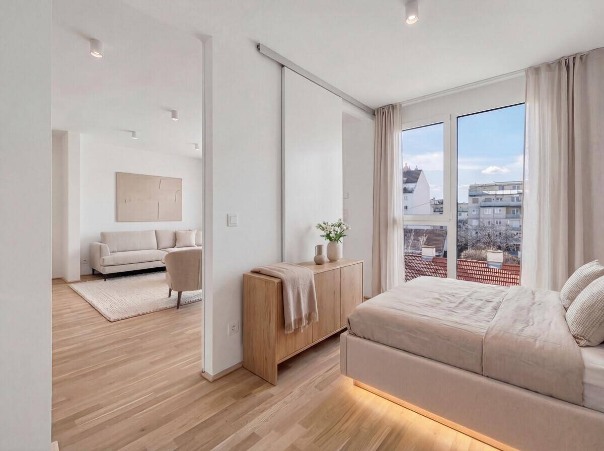 Modernes Schlafzimmer mit Holzboden und indirekter Beleuchtung, offen zum angrenzenden Wohnbereich.